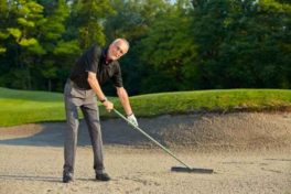 senior-golfer-rake-the-bunker